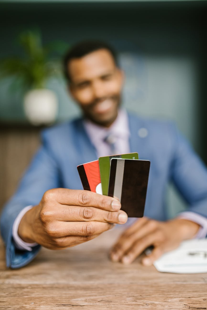 man in blue suit holding credit cards